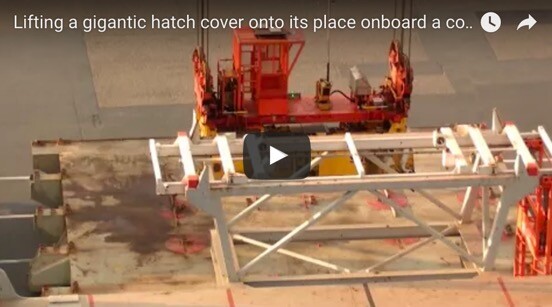  Lifting a gigantic hatch cover into place onboard a container ship. 